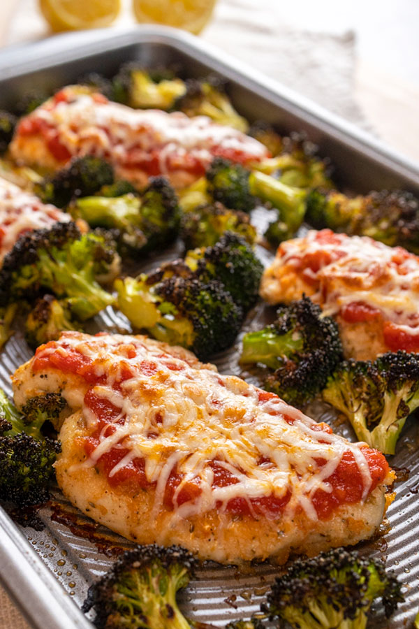A sheet pan of chicken parmesan with roasted lemon-garlic broccoli