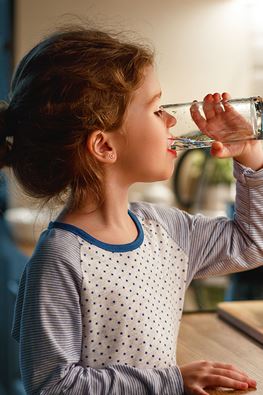 Young girl drinking water as a healthy habit