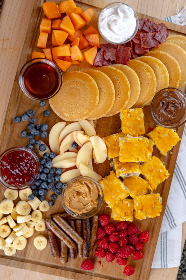Breakfast snack-board filled with fruit, pancakes and so much more.